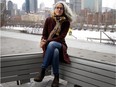 Bochra Manai sits on a park bench with the Montreal skyline behind her