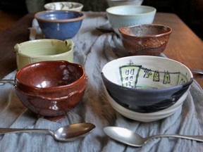 Decorated pottery bowls with spoons next to them.