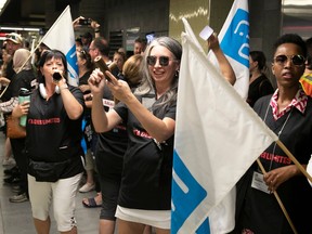 Nurses wave banners and blow horns during a protest inside the Montmorency métro station on Sept. 6, 2023.
