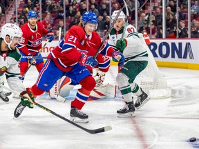Canadiens defenceman Kaiden Guhle skates between Minnesota Wild Marcus Johansson, left, and Kirill Kiprizov to chase loose puck during game last month at the Bell Centre.