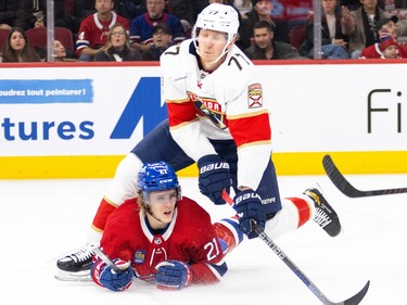Montreal Canadiens' Kaiden Guhle lies on the ice underneath a Panthers player