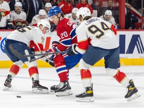 Montreal Canadiens' Juraj Slafkovsky stick-handles between two Panthers players