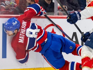 Montreal Canadiens' Mike Matheson is splayed nearly horizontal against the side boards