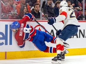 Montreal Canadiens' Mike Matheson is splayed nearly horizontal against the side boards
