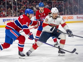 Montreal Canadiens' Mike Matheson pokes the puck away from Florida Panthers' Ryan Lomborg