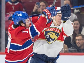 A Canadiens and Florida player get their sticks caught up above their head