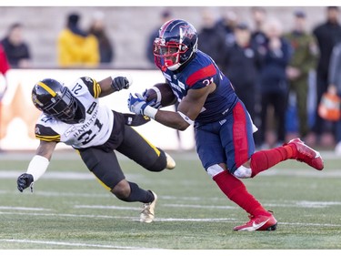 Alouettes running back William Stanback runs by Hamilton Tiger-Cats linebacker Simoni Lawrence for a first down during second half of Canadian Football League East Division semifinal playoff game against the Hamilton Tiger-Cats in Montreal on Saturday, Nov. 4, 2023.