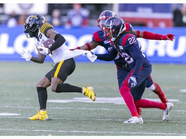 Alouettes Dionte Ruffin and Reggie Stubblefield grab Hamilton Tiger-Cats Terry Godwin II during first half of Canadian Football League East Division semifinal playoff game against the Hamilton Tiger-Cats in Montreal on Saturday, Nov. 4, 2023.
