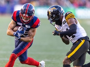 Alouettes reciever Jake Harty protects the football from hit by Tiger-Cats' Dexter Lawson Jr. on his way to a touchdown during fourth quarter at Molson Stadium on Nov. 4.