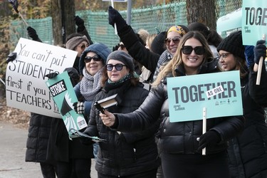 A row of women holding up signs on a picket line