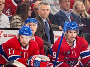 Canadiens head coach Martin St. Louis watches the play standing behind three Canadiens players