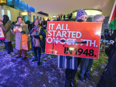 A woman holds a banner that reads 'It all started in 1948'