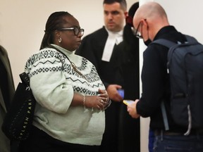 A woman waits to enter a courtroom.