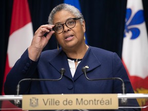 Dominique Ollivier, at a city of Montreal podium, adjusts her glasses as she speaks