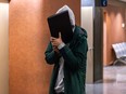 Mohamed Amine Assal, who was arrested in March in Ville Saint-Laurent by the RCMP, hides from cameras as he leaves the Palais de Justice in Montreal on Tuesday, Nov. 14, 2023.