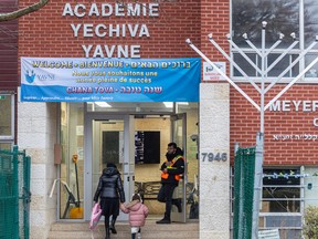 A security guard is posted at the door of Academie Yechiva Yavne in Montreal on Tuesday, Nov. 14, 2023.