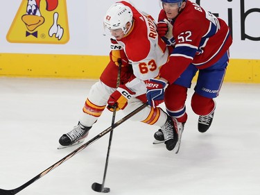 Montreal Canadiens' Justin Barron (52) puts pressure behind Calgary Flames' Adam Ruzicka (63), who is playing with the puck