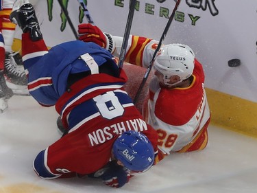 Montreal Canadiens' Mike Matheson lies face down partially on top of Calgary Flames' Elias Lindholm