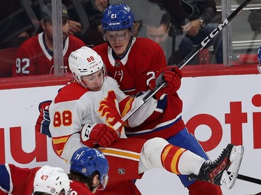 Montreal Canadiens' Kaiden Guhle and Calgary Flames' Andrew Mangiapane along the boards