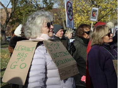 A woman wears a sign reading Stop Inciting Intolerance at a Bill 96 protest.