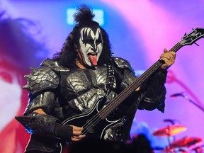 Gene Simmons of Kiss plays bass while sticking out his tongue.