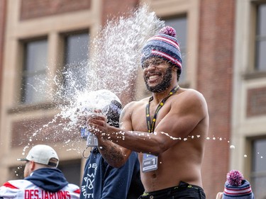 Liquid sprays from Tyrell Richards's hands as he smashes beer cans together while riding shirtless in an open-top vehicle