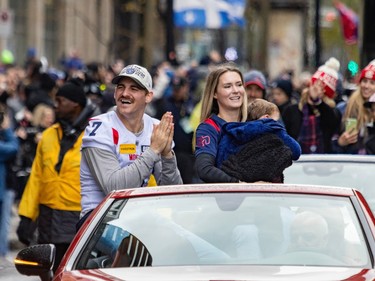 Cody Fajardo puts his hands together while sitting in the back of an open-top vehicle during a parade