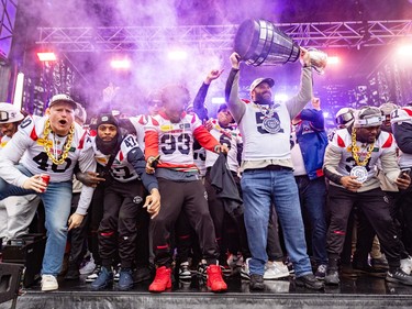 Kristian Matte raises the Grey Cup with several other cheering Alouettes players on stage