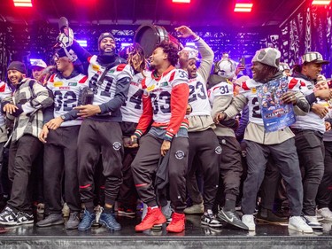 Alouettes players celebrate on stage
