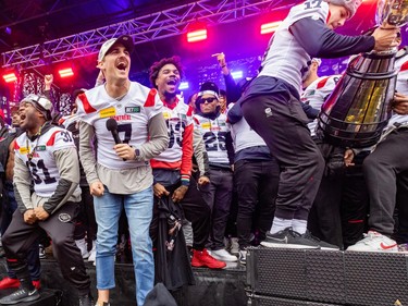 Alouettes quarterback Cody Fajardo, with a microphone in his hand, celebrates with teammates after the team's Grey Cup parade in Montreal on Wednesday.