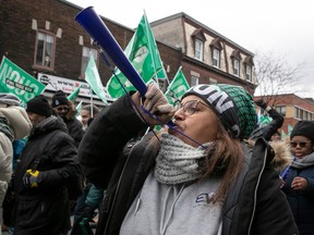 "Common front" demonstrators blow horns and carry signs during protests in Montreal by Quebec's public sector workers, on Nov. 23, 2023.