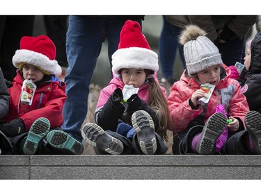 Kids make sure to stay hydrated during the Montreal Santa Claus parade on Saturday, Nov. 25, 2023.