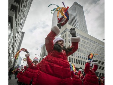 Participants make their way near Place Ville Marie while taking part in the Santa Claus parade on Saturday, Nov. 25, 2023.