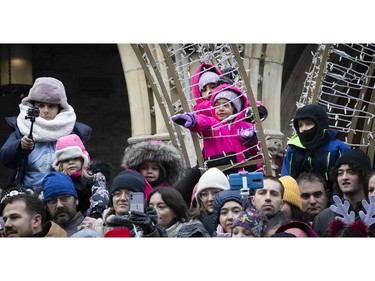 Youngsters make sure they're above the crowd to see the Montreal Santa Claus parade on Saturday, Nov. 25, 2023.