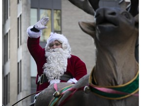 Santa Claus waves to the crowd as he travels down Ste-Catherine St. in Montreal during the annual parade on Saturday, Nov. 25, 2023.