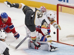 Vegas Golden Knights' William Carrier bends over the Canadiens goaltender with the puck in the air
