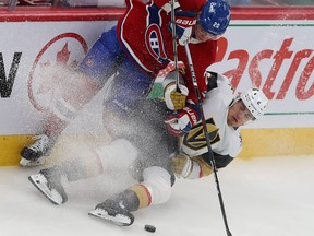 Montreal Canadiens' Juraj Slafkovsky on top of a falling Vegas Golden Knights' Zach Whitecloud with the puck underneath them