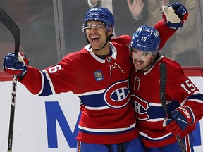 Canadiens defenceman Johnathan Kovacevic and Alex Newhook embrace and smile along the boards