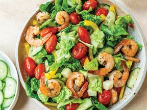 Roasted tomato and shrimp salad on a white plate.
