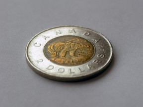 A Canadian $2 coin on a grey surface