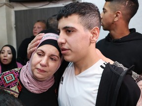 Ahmad Salaima is welcomed by his mother upon his arrival at his home in Israeli-annexed east Jerusalem on Nov. 28, 2023.