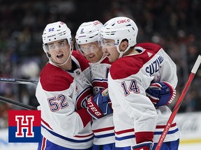 Three hockey players embrace after scoring a goal