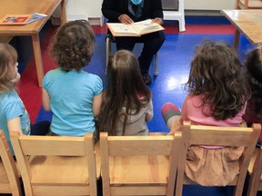 A daycare educator reads to kids at a Montreal daycare.