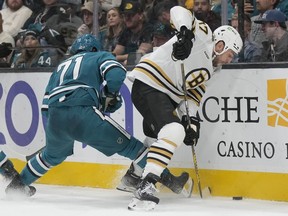 Boston Bruins' Milan Lucic (17) reaches for the puck in front of San Jose Sharks defenceman Nikolai Knyzhov (71) in San Jose, Calif., on Oct. 19, 2023.