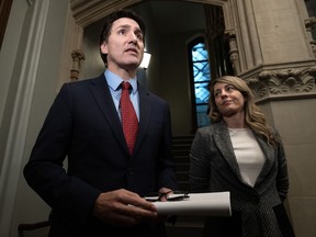 Minister of Foreign Affairs Mélanie Joly looks on as Prime Minister Justin Trudeau speaks to reporters