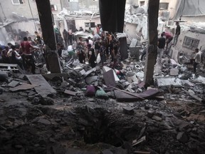 Palestinians look for survivors under the rubble of a destroyed house following an Israeli airstrike in Khan Younis refugee camp, southern Gaza Strip, Monday, Nov. 13, 2023.