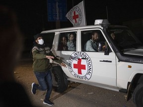 A Red Cross vehicle carrying Israeli hostages drives by at the Gaza Strip crossing into Egypt in Rafah on Saturday, Nov. 25, 2023. Jewish and Muslim groups in Canada say they are closely following the ongoing ceasefire between Israel and Hamas.