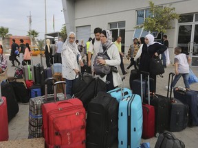 Palestinians arrive at the border crossing to Egypt in Rafah, Gaza Strip, on Monday, Nov. 13, 2023. Canadians who escaped the Gaza Strip are desperate to help the family they behind, but say Canada's definition of family means their loved ones' lives are in danger indefinitely.