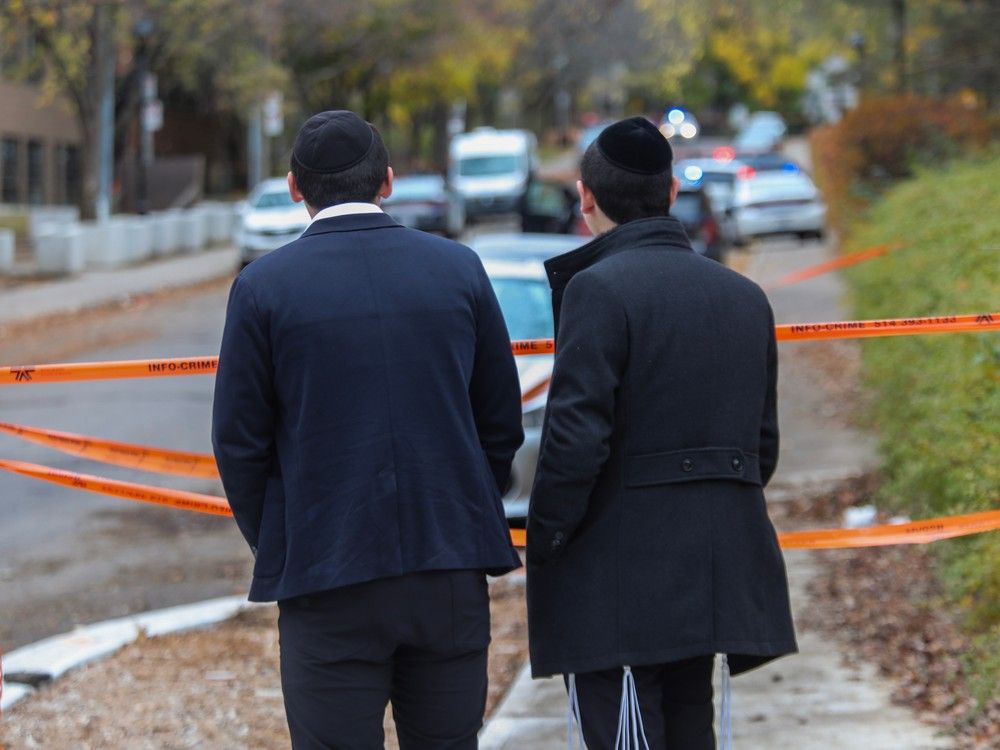 Young men look toward Yeshiva Gedola of Montreal on Deacon Rd. on Sunday, November 12, 2023, after gunshots were fired at the school.