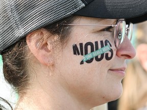 Woman with Nous written on her face in solidarity with the strike